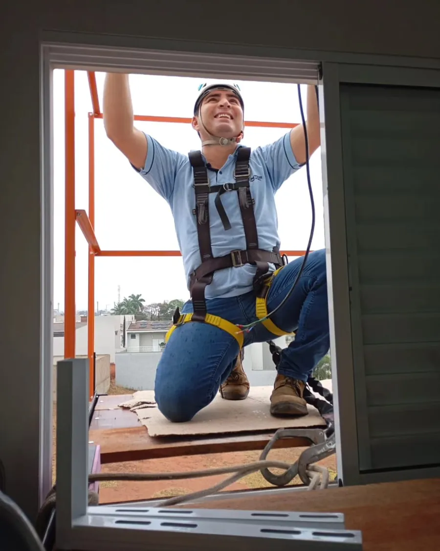 Técnico da Climatizza instalando um ar condicionado pela janela